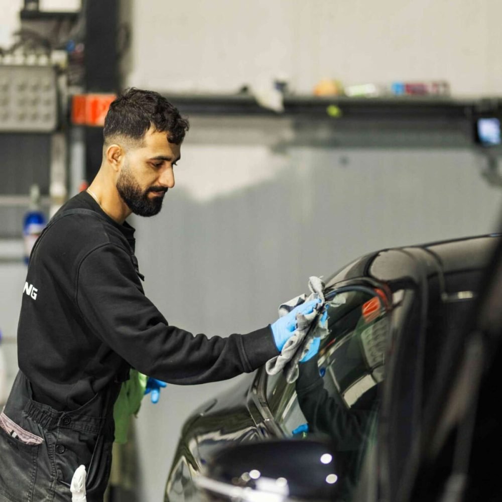 Medewerker behandelt een carrosseriepaneel van een auto